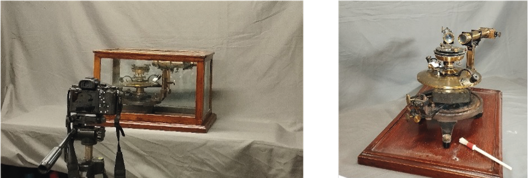 Un antico apparecchio scientifico in metallo e vetro è esposto su una base di legno con una fotocamera montata su un treppiede rivolta verso di esso.

Descrizione generata da AI